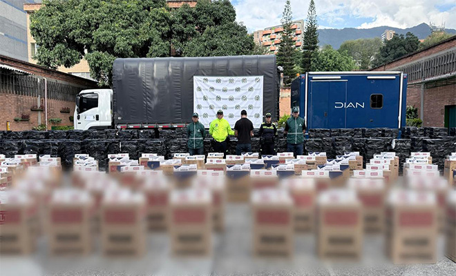 policias custodiando cigarrillos incautados y a una persona capturada