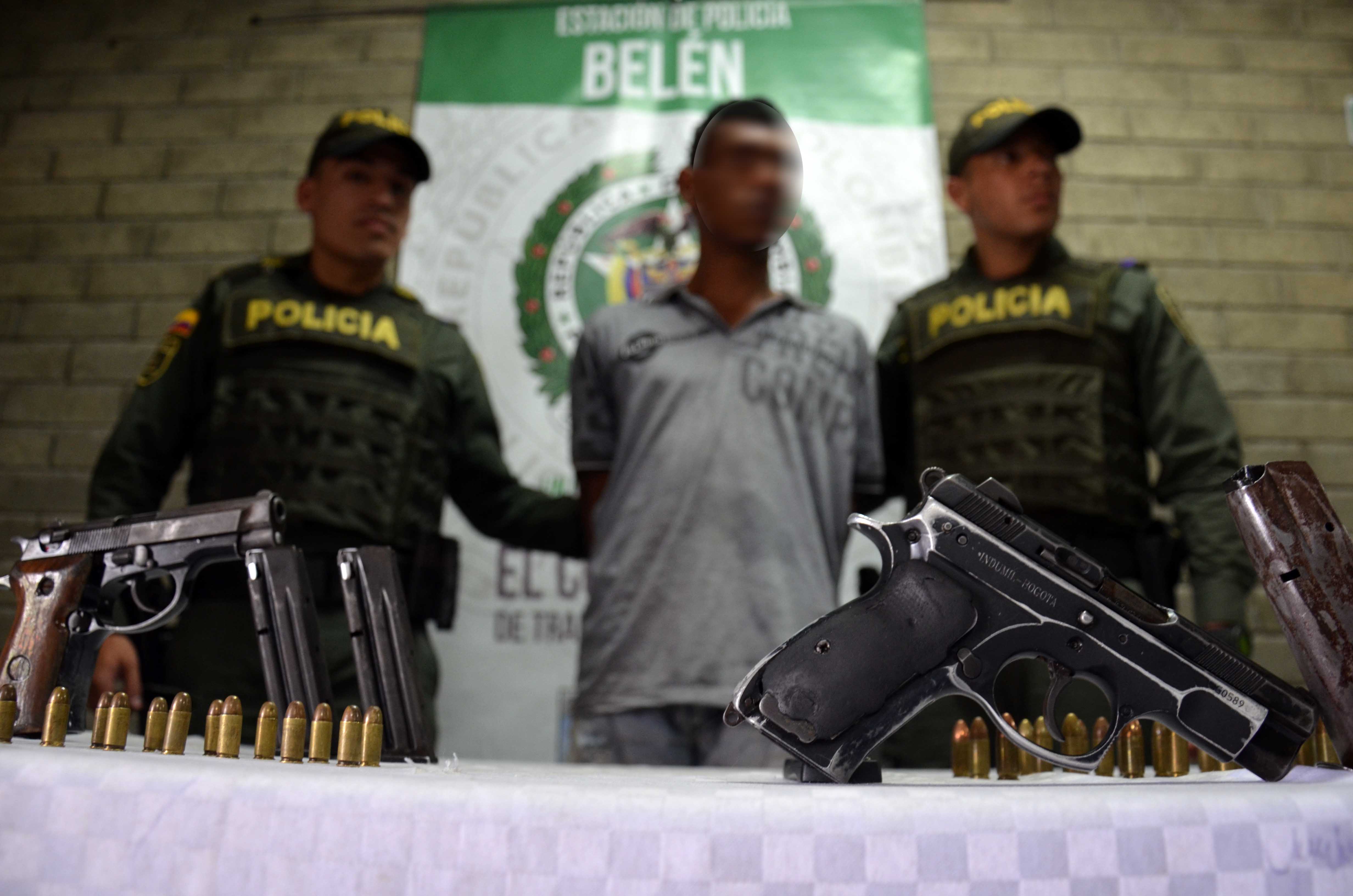 Policía custodian a un capturado en Medellín con dos armas de fuego