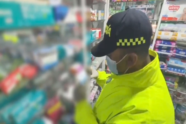 Policía verificando medicamentos realizando Planes de control y revisión en una droguerías