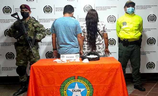 2 personas capturadas-policías custodiando-alucinógenos incautados.