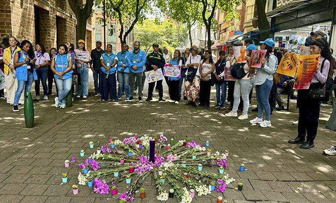 policías, autoridades locales, comunidad y flores en el piso