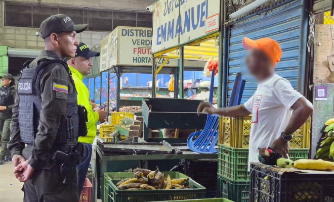 Dos policías brindan recomendación a comerciante.