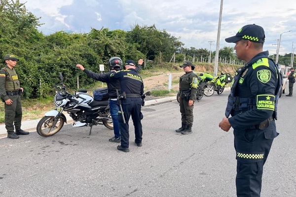 Cuatro Policías en vía publica y uno de ellos practicando registro a persona a un ciudadano