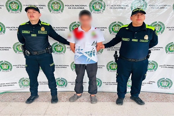 Dos funcionarios custodian a un hombre capturado