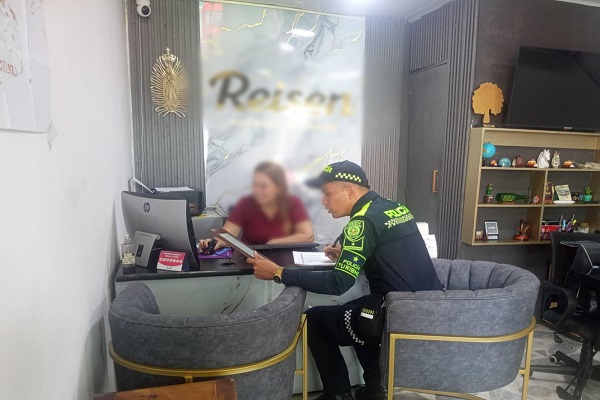 Policía de turismo realizando actividad de vigilancia y control en agencia de viajes