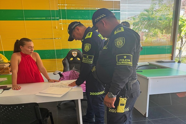 Dos policías verifican la documentación de un establecimiento turístico