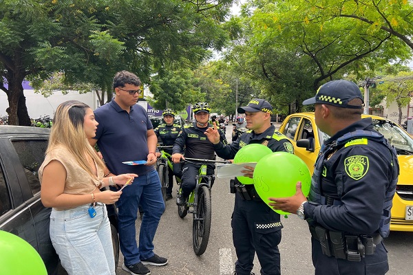 Dos policías y uniformados en bicicleta socializan recomendaciones a dos ciudadanos