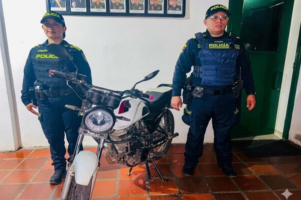 Dos polic&iacute;as junto a una motocicleta recuperada