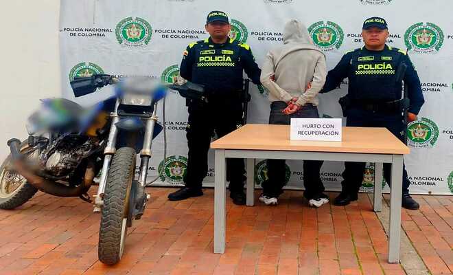 policías con persona capturada y motocicleta recuperada