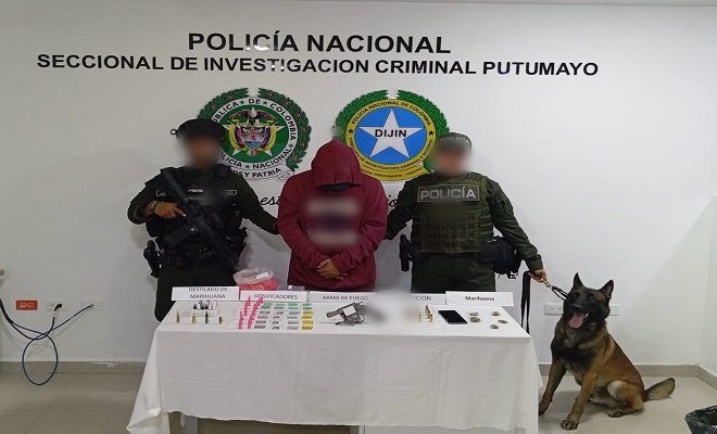 Dos policías, un canino frente a un capturado y elementos con estupefacientes sobre una mesa incautados