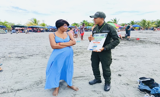Un Policía realizando una campaña denominada abre tus ojos en las playas del Morro de Tumaco 