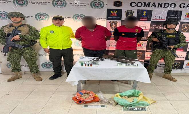 Dos personas capturadas esposadas con material b&eacute;lico incautado y estupefacientes, asimismo, Polic&iacute;a Judicial y GAULA Militar a sus lados respectivamente