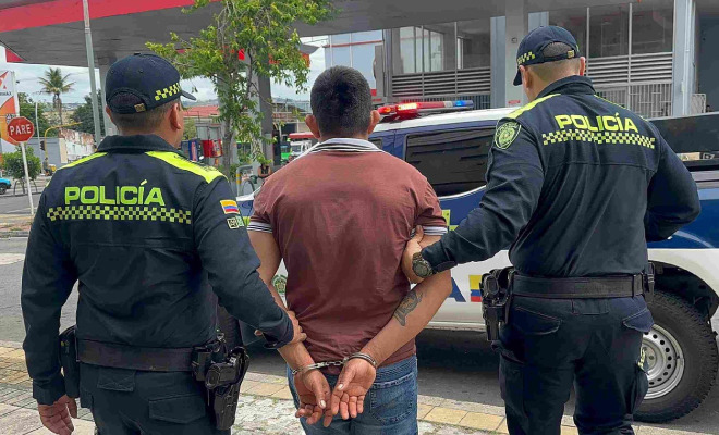 Hombre capturado en medio de dos Policías