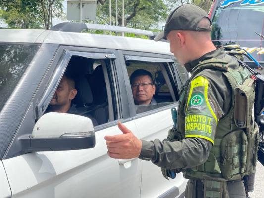 un policía al lado de dos ciudadanos brindando información 