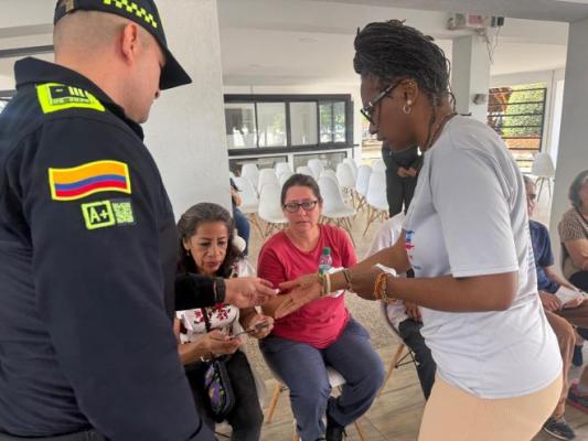 un policía al lado de la ciudadanía entregando gafas