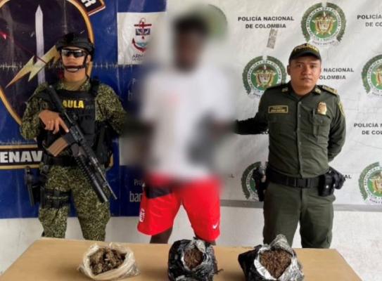 un policía al lado de un hombre capturado por estupefacientes 