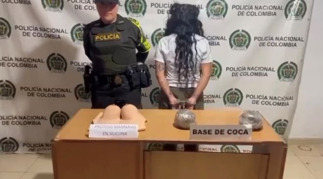 una mujer policía al lado de una mujer capturada con base de coca y un chaleco de silicona que simulaba prótesis mamarias