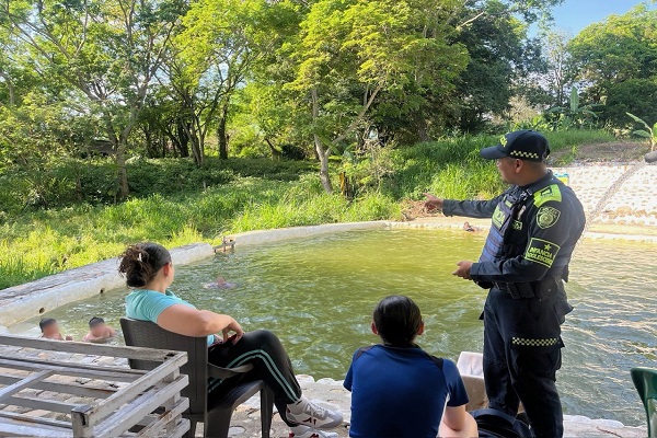 Policía de infancia y adolescencia compartiendo recomendaciones a dos ciudadanas en centro recreativo