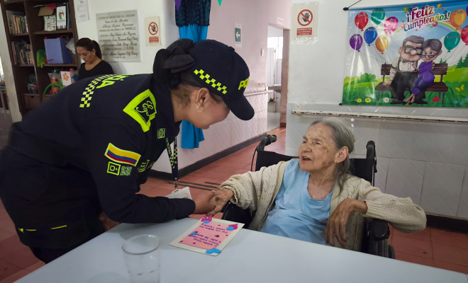 Adulta mayor interactuando con uniformada de la Policía